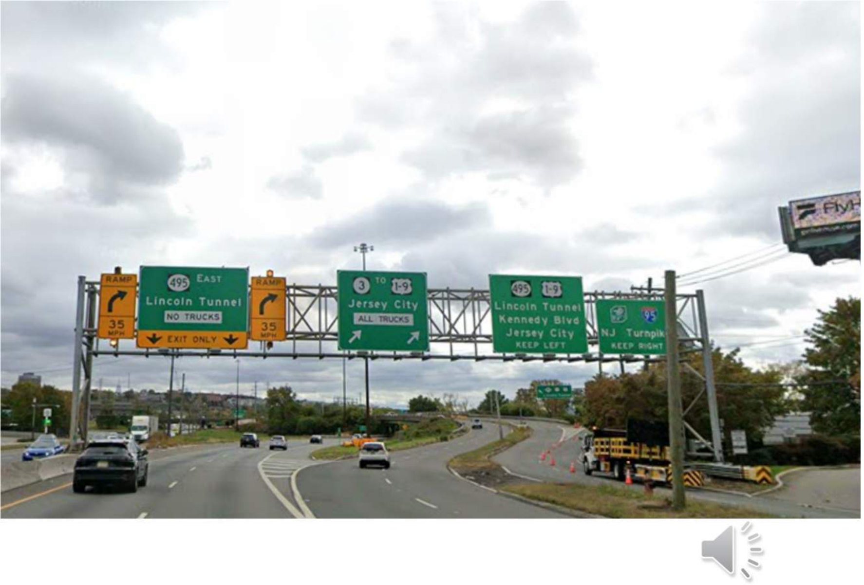 Estructuras de señalización elevadas sobre la calzada que se aproxima al intercambio, señalizadas hacia la Ruta 495 este, el Túnel Lincoln, Jersey City y la NJ Turnpike.